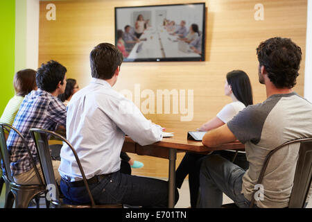 Designers Sitting Around Table In Meeting Looking At Screen Stock Photo