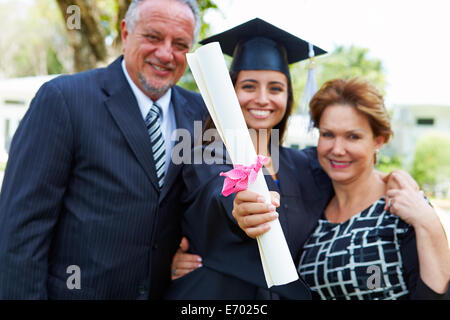 Hispanic Student And Parents Celebrate Graduation Stock Photo