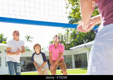 Male Multi Generation Family Playing Volleyball In Garden Stock Photo