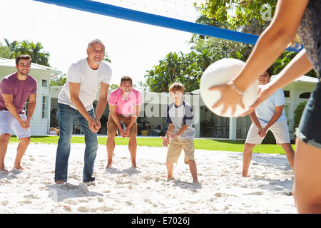 Male Multi Generation Family Playing Volleyball In Garden Stock Photo