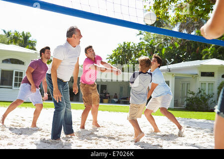 Male Multi Generation Family Playing Volleyball In Garden Stock Photo