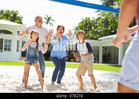Grandparents And Grandchildren Playing Volleyball In Garden Stock Photo