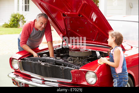 Grandfather And Granddaughter Working On Classic Car Stock Photo