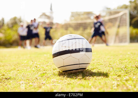 Close Up Of Soccer Ball With Players In Background Stock Photo
