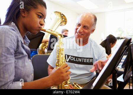 Girl Learning To Play Saxophone In High School Orchestra Stock Photo
