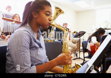 Female Pupil Playing Saxophone In High School Orchestra Stock Photo