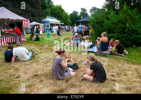 People sitting in the gardens at Strawberry Hill House eating strawberries at summer fair in Twickenham, London  KATHY DEWITT Stock Photo