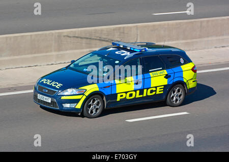 Close up Essex Police Ford car dog unit emergency response call travelling fast on blue lights along lane four M25 motorway Essex England UK Stock Photo