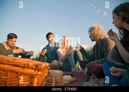 Five adult friends having picnic on Bournemouth beach, Dorset, UK Stock Photo