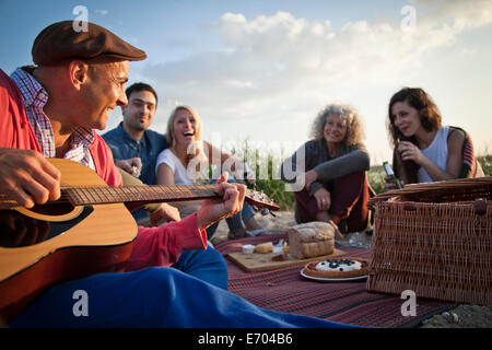 Five adult friends picnicing on Bournemouth beach, Dorset, UK Stock Photo