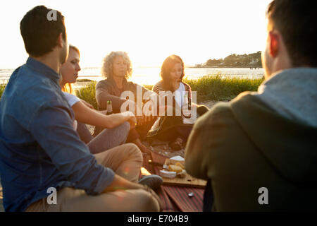 Five adult friends having picnic on Bournemouth beach, Dorset, UK Stock Photo