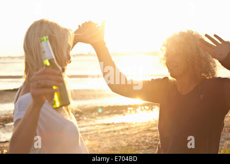 Mature mother and daughter dancing on Bournemouth beach, Dorset, UK Stock Photo