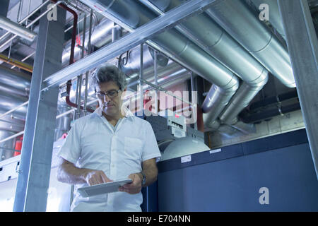 Engineer using touchscreen on digital tablet in power station Stock Photo