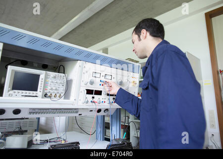 Male electrician testing control panel in workshop Stock Photo