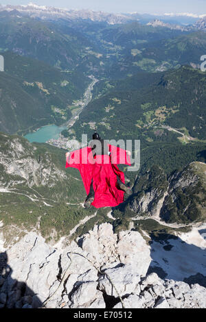 Mature man BASE jumping from mountain, Alleghe, Dolomites, Italy Stock Photo