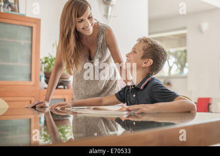 Mother and son doing homework at dining room table Stock Photo