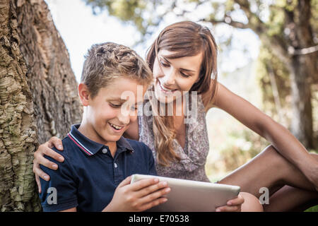 Mother and son looking at digital tablet in holiday home garden, Capoterra, Sardinia, Italy Stock Photo