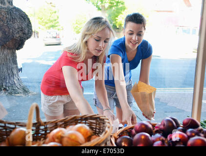 Two young women choosing food at market stall Stock Photo