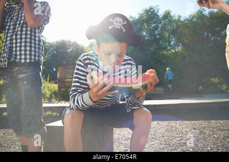 Three young boys having lunch in park Stock Photo