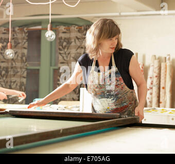 Woman hand-printing textile in workshop Stock Photo