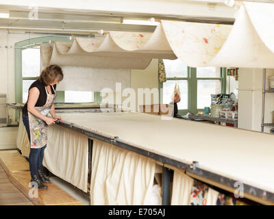 Woman working by drying system in hand-printing textile workshop Stock Photo