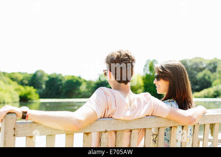 Couple sitting on wooden park bench Stock Photo