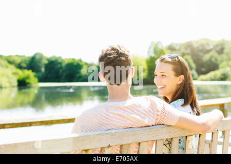 Couple sitting on wooden park bench Stock Photo