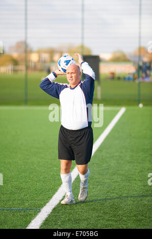 Football player throwing ball to start game Stock Photo