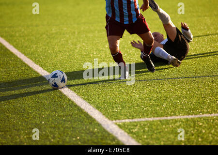 Football players down on ground during game Stock Photo