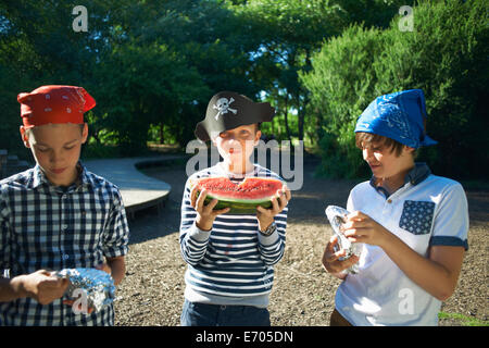 Three young boys having lunch in park Stock Photo