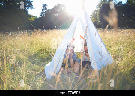 Two young boys sitting inside a teepee Stock Photo