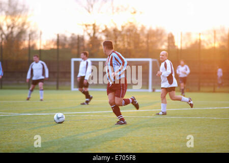 Football players running after ball Stock Photo