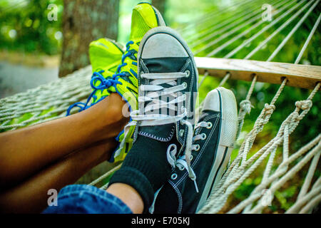 Legs of teenage boys lying in hammock Stock Photo