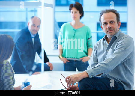 Portrait of businessman, colleagues having discussion in background Stock Photo