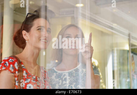 Two young women looking and pointing at shop window Stock Photo