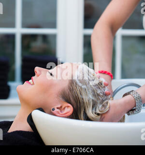Woman having hair shampooed in salon Stock Photo