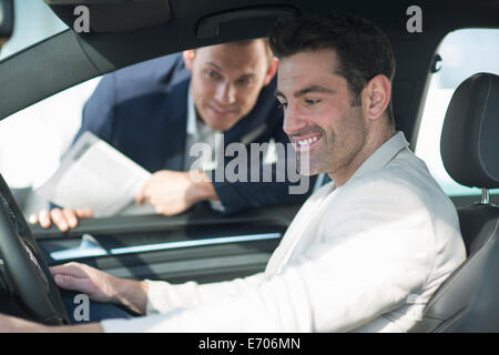 Customer trying out new car in car dealership Stock Photo