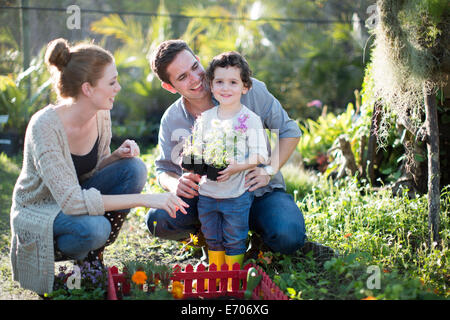 Couple and son planting miniature garden on allotment Stock Photo