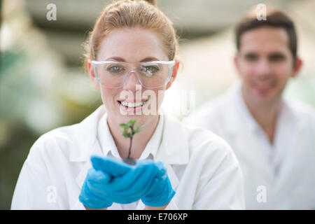 Portrait of female scientist holding up plant sample Stock Photo
