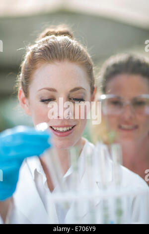 Two female scientists monitoring plant samples in test tubes Stock Photo