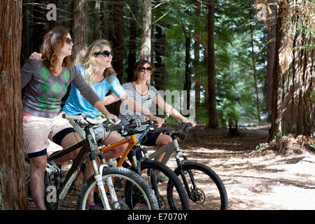 Portrait of three women mountain bikers in forest Stock Photo