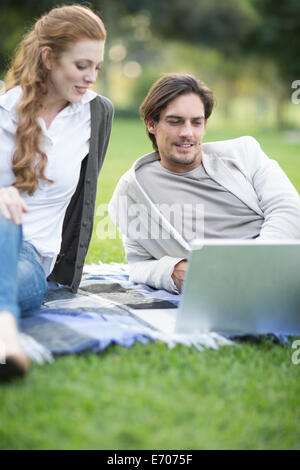 Businessman and female colleague looking at laptop in park Stock Photo