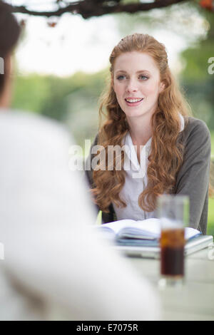 Businessman and female colleague having informal meeting in garden Stock Photo