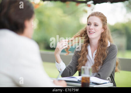 Over the shoulder view of businessman and female colleague having informal meeting in garden Stock Photo