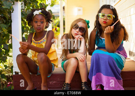 Three girls pulling faces on porch Stock Photo