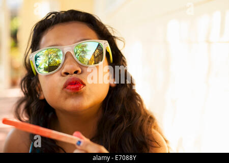 Portrait of girl with red lips and ice lolly stick pulling face Stock Photo