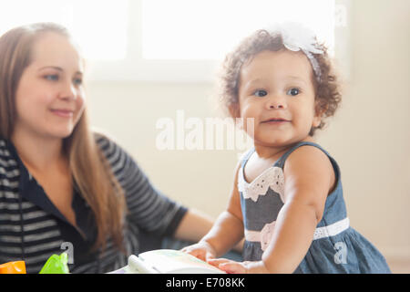 Mother watching young daughter play Stock Photo