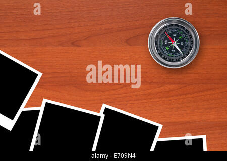 Blank, black picture frames with compass on wooden table. Stock Photo