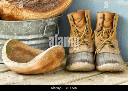 Bean boots with wooden bowls on a porch. Stock Photo