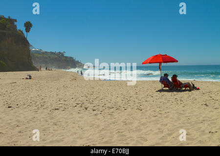 Bright red umbrella on Thousand steps Beach in Laguna Beach California Stock Photo